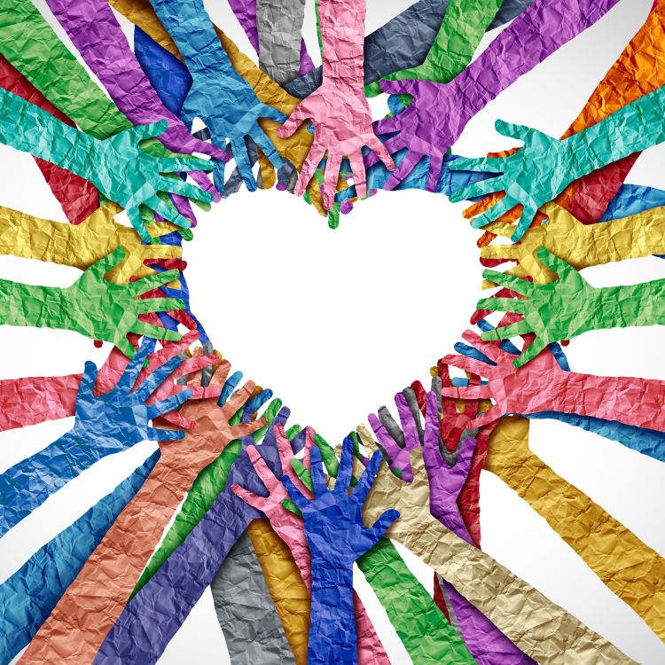 Group of multicoloured paper hands making the shape of a heart