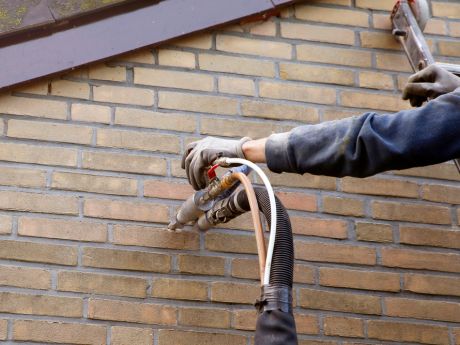 Cavity wall insulation being piped into building