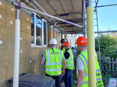 External wall insulation with surveyors looking on