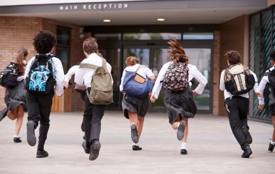 Group of Children in School Uniform running into school